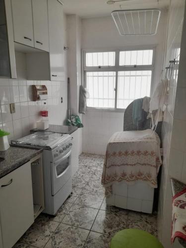 a kitchen with a stove and a table in it at Ap 300m praia do morro in Guarapari