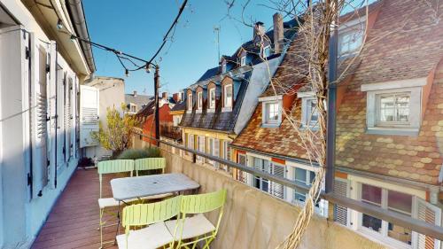 a balcony with a table and chairs on a building at L'Appart du Quai avec Terrasse in Strasbourg