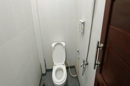 - une salle de bains avec des toilettes blanches dans une cabine dans l'établissement OYO 92243 Fanilly Guest House Marabahan, à Banjarmasin