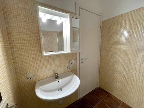 ein Badezimmer mit einem weißen Waschbecken und einem Spiegel in der Unterkunft Dammusi cala croce in Lampedusa
