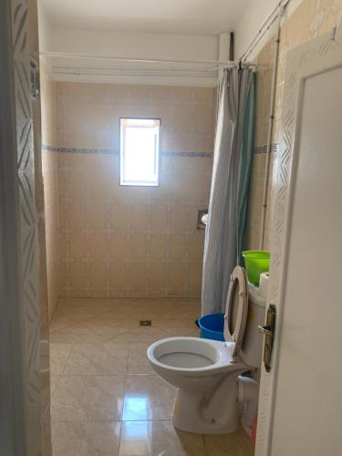 a small bathroom with a toilet and a window at Appartement, tilila in Mirleft