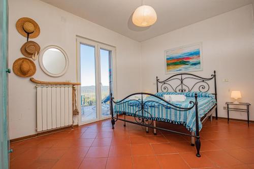 a bedroom with a bed and a large window at Affitti Brevi Toscana - La vista su Talamone in Fonteblanda