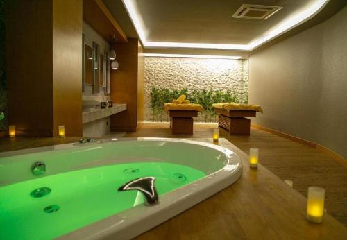 uma banheira verde numa casa de banho com 2 velas em Soul Entertainment Group em Esenyurt