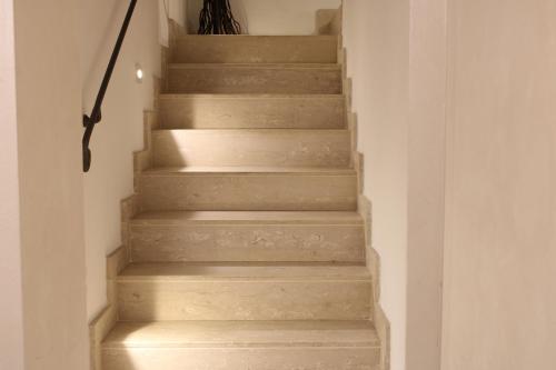 a stairway withbrown stairs with a white wall at PIUMABLU in Campi Bisenzio