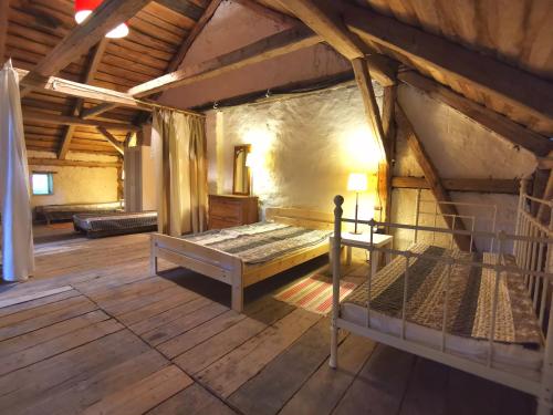 an attic room with a bed in a building at Mazurski Ogród - dom z ogrodem, kominkiem i wiatą biesiadną in Wydminy