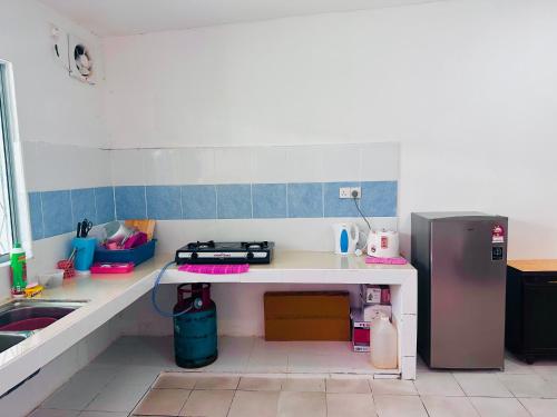 Bella Homestay Beaufort Sabah في بوفورت: مطبخ صغير مع مغسلة وثلاجة