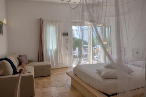 a bedroom with a bed and a couch and a window at Cuti Mari in Otranto