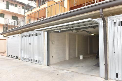 a large garage with white doors and a balcony at Design & Comfort a Romano di L. in Romano di Lombardia