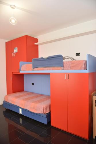 two bunk beds in a room with orange and blue cabinets at Design & Comfort a Romano di L. in Romano di Lombardia