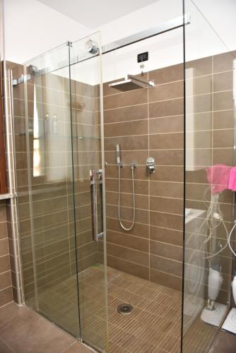 y baño con ducha y puerta de cristal. en Design & Comfort a Romano di L., en Romano di Lombardia