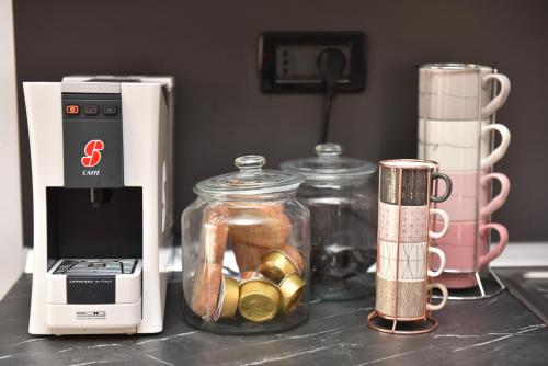 a counter with a blender and a jar of gold coins at Design & Comfort a Romano di L. in Romano di Lombardia