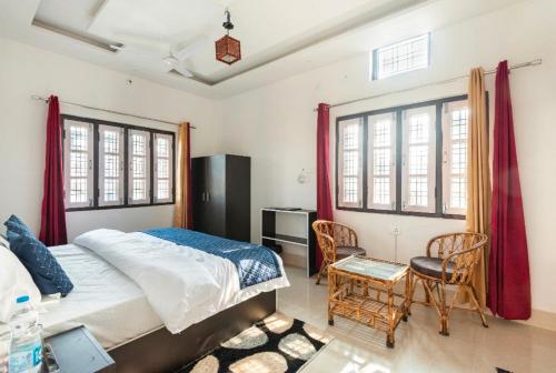 Janki homestay في Rāiwāla: غرفة نوم بسرير وطاولة وكراسي