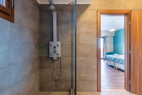 La salle de bains est pourvue d'une douche avec une porte en verre. dans l'établissement Apokoronas Views Villa, à Néon Khoríon