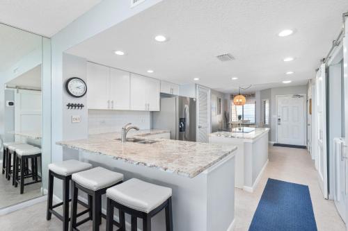 a kitchen with a large island with bar stools at Windjammer 403 in Cedar Landing