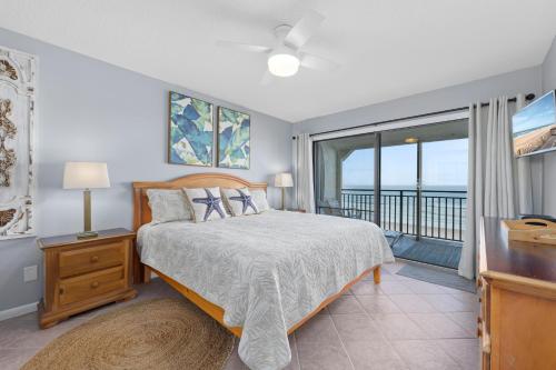 a bedroom with a bed and a balcony at Windjammer 403 in Cedar Landing