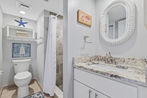 a bathroom with a toilet and a sink and a mirror at Windjammer 403 in Cedar Landing