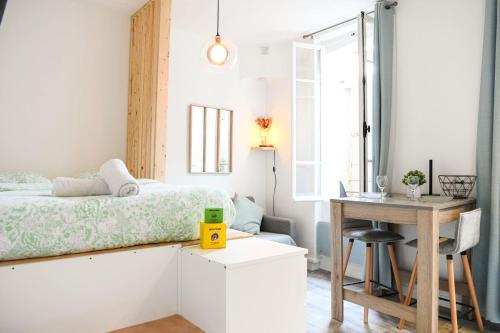 - une petite chambre avec un lit et un bureau dans l'établissement Studio cosy avec terrasse au coeur de Marseille, à Marseille
