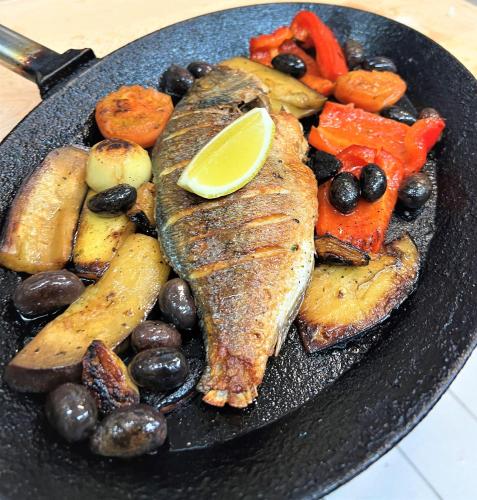 a black plate of food with fish and vegetables at Schlosshotel Marienbad in Mariánské Lázně