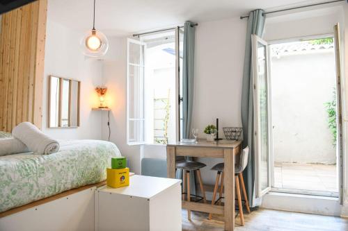 a bedroom with a bed and a desk and a window at Studio cosy avec terrasse au coeur de Marseille in Marseille
