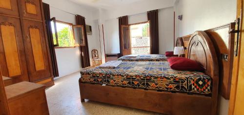 una camera da letto con un letto con testiera in legno di Nile View Panoramique and Garden West bank a Luxor