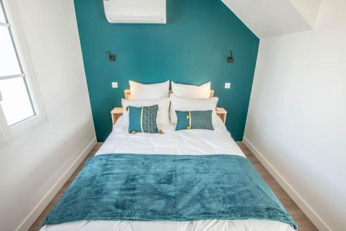 a bedroom with a bed with a blue wall at LE COMMODORE Maison avec piscine/parking/wifi/plages 5kms in Les Mathes