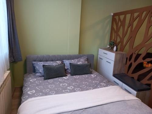 a bedroom with a bed with two pillows and a dresser at Apartman Reset in Pale
