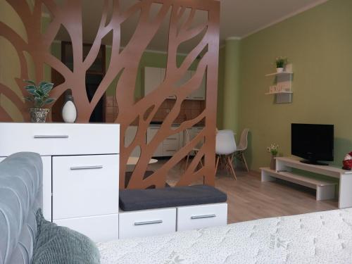 a bedroom with a white dresser and a living room at Apartman Reset in Pale