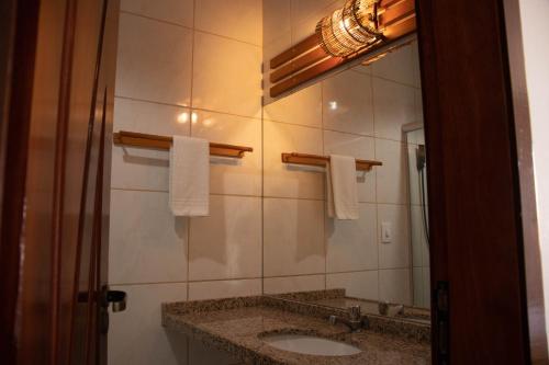 a bathroom with a sink and a mirror at Milos Beach Hotel in Aquiraz