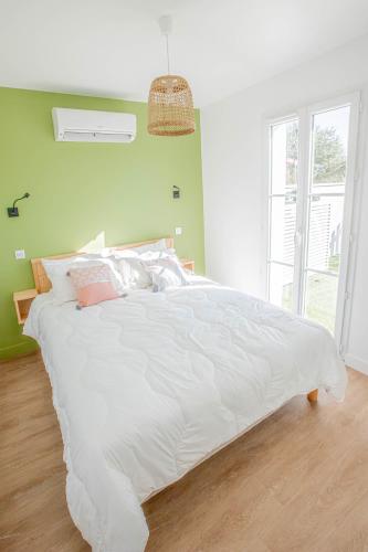 un grand lit blanc dans une chambre avec une fenêtre dans l'établissement LE VAISSEAU Maison avec piscine/parking/wifi/plages 5kms, aux Mathes