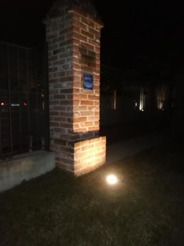 a brick pillar with a light on it at night at Ospitidelpero in Piozzo