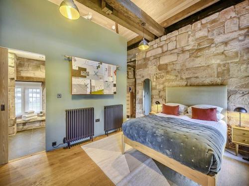 a bedroom with a large bed in a stone wall at Swanswell Gate in Coventry