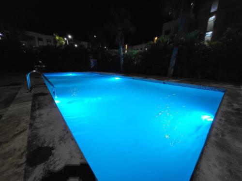 a swimming pool with blue illumination at night at Oasis Palma Real santiago, Republica Dominicana in Santiago de los Caballeros