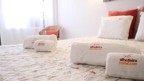 a bed with white towels on top of it at Coral By Albufeira Rental in Albufeira