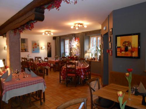 um restaurante com mesas e cadeiras num quarto em Au Fief du Château em Orschwiller