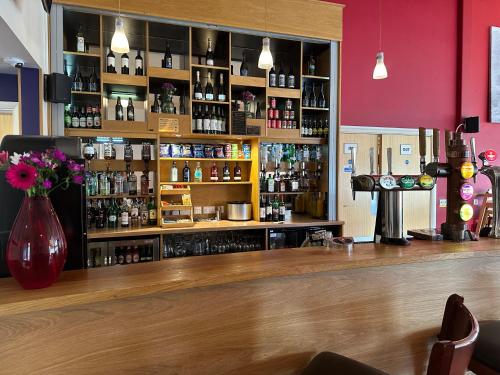 a bar with a counter with bottles of alcohol at Wookey Hole Hotel in Wells