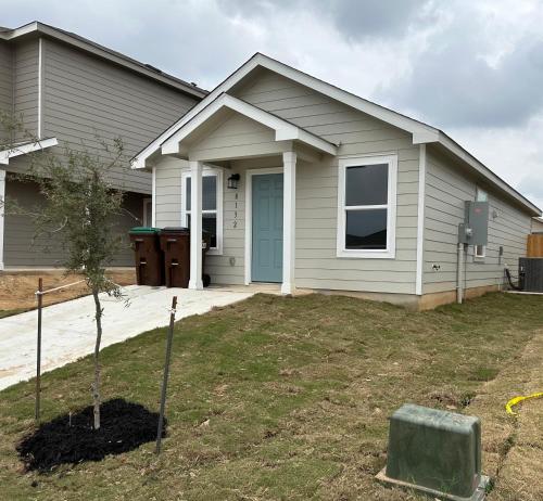 a house with a tree in front of it at Lackland-area new cozy 2BR home in San Antonio