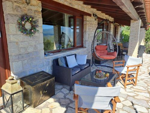 a patio with chairs and a swing and a stove at Petra Thea Villa Karitaina in Karítaina