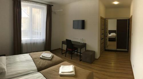 a bedroom with a bed and a table and a mirror at Leo Rooms in Lviv