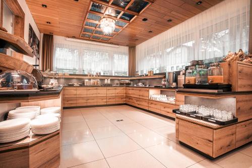 a large kitchen with wooden cabinets and white plates at Hotel-Restaurant Barbarossahof in Kaiserslautern