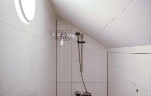 a shower in a bathroom with white tiles at Cozy Apartment In rdalstangen With Wifi in Årdalstangen
