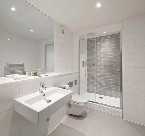 a bathroom with a sink and a toilet and a shower at Signature Townhouse London Hyde Park in London