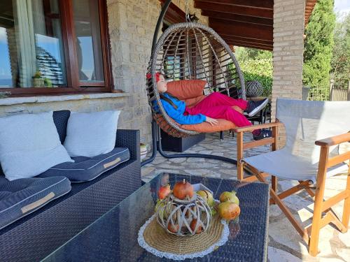 a swing on a porch with a chair and a table at Petra Thea Villa Karitaina in Karítaina