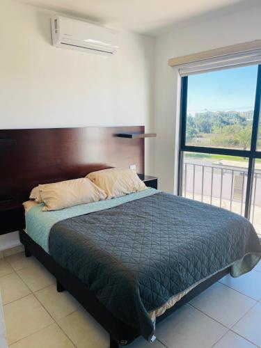 uma cama num quarto com uma grande janela em Nuevo departamento a solo 3 min de la playa con todos los servicios em La Florida