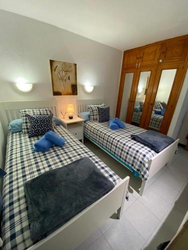 a bedroom with two beds with blue pillows at CASA SANDRA COCOSOL in Costa de Antigua
