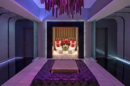 a purple room with a couch and a chair at W Bali - Seminyak in Seminyak