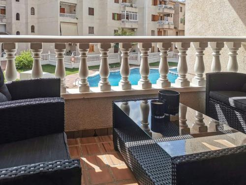 balcone con sedie, tavolo e ringhiera di Casa Del Angel , Cosy 2 bed apartment,150m from Playa Los Locos plus beautiful swimming pool a Torrevieja