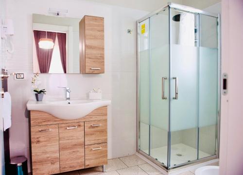 La salle de bains est pourvue d'un lavabo et d'une douche en verre. dans l'établissement Ottaviano B&B, à Ottaviano
