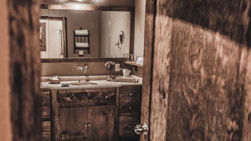 a bathroom with a sink and a large mirror at Hacienda Sepulveda Hotel & Spa in Lagos de Moreno