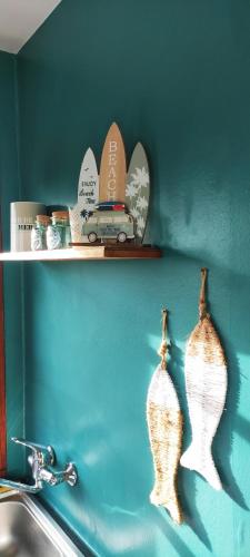 une étagère avec deux vases sur un mur à côté d'un évier dans l'établissement Le Bout des Dunes, baie de Somme, à Saint-Quentin-en-Tourmont