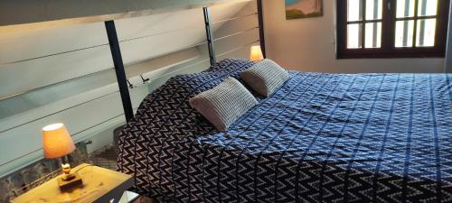 um quarto com uma cama com um edredão azul em Le Bout des Dunes, baie de Somme em Saint-Quentin-en-Tourmont